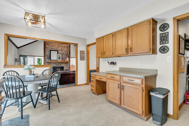 11534 Capistrano Cir, Indianapolis, IN 46236 - kitchen with a fireplace, light countertops, lofted ceiling, and a textured ceiling