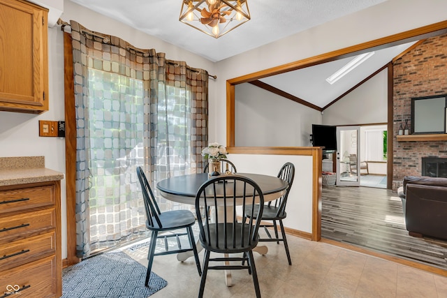 11534 Capistrano Cir, Indianapolis, IN 46236 - dining area featuring lofted ceiling, plenty of natural light, a chandelier, and a brick fireplace