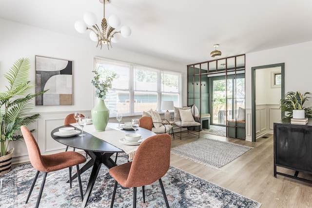 316 Ohmer Ave, Indianapolis, IN 46219 - dining space featuring a decorative wall, light wood-style flooring, a chandelier, and wainscoting