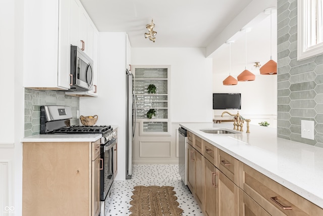 316 Ohmer Ave, Indianapolis, IN 46219 - kitchen with appliances with stainless steel finishes, backsplash, white cabinets, and hanging light fixtures