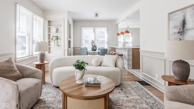 316 Ohmer Ave, Indianapolis, IN 46219 - living area with healthy amount of natural light, light wood-style flooring, wainscoting, and a decorative wall