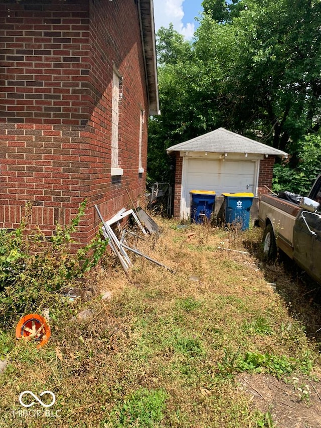 4547 Zoeller Ave, Indianapolis, IN 46226 - view of side of home featuring brick siding, a garage, and an outbuilding