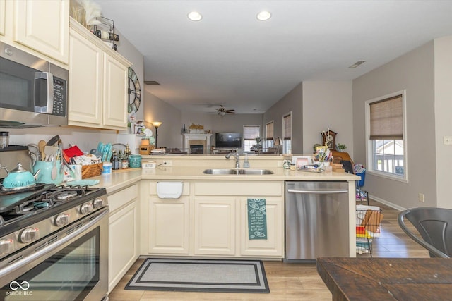 4285 Washington Blvd, Plainfield, IN 46168 - kitchen featuring stainless steel appliances, a peninsula, light wood-style floors, a ceiling fan, and recessed lighting