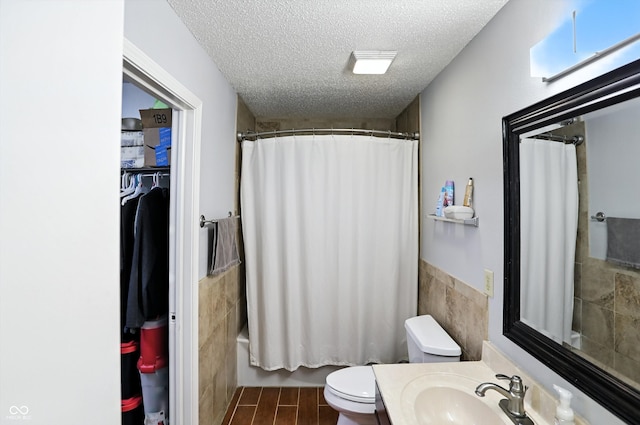 2421 Amberleigh Dr, Plainfield, IN 46168 - bathroom featuring tile walls, a textured ceiling, vanity, shower / bath combo with shower curtain, and a wainscoted wall