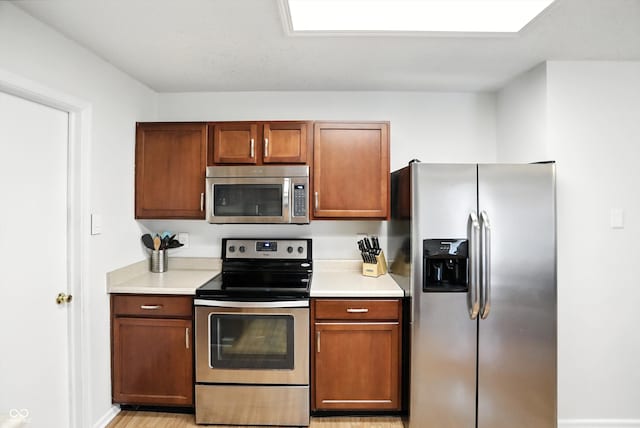 2421 Amberleigh Dr, Plainfield, IN 46168 - kitchen with stainless steel appliances, light countertops, and brown cabinetry