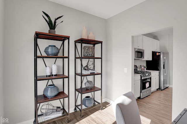 6655 Halsey St, Zionsville, IN 46077 - kitchen featuring appliances with stainless steel finishes, light wood finished floors, white cabinets, and light countertops