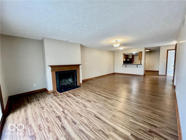 35 Northridge Ct, Brownsburg, IN 46112 - unfurnished living room with wood finished floors, a textured ceiling, and a fireplace with flush hearth