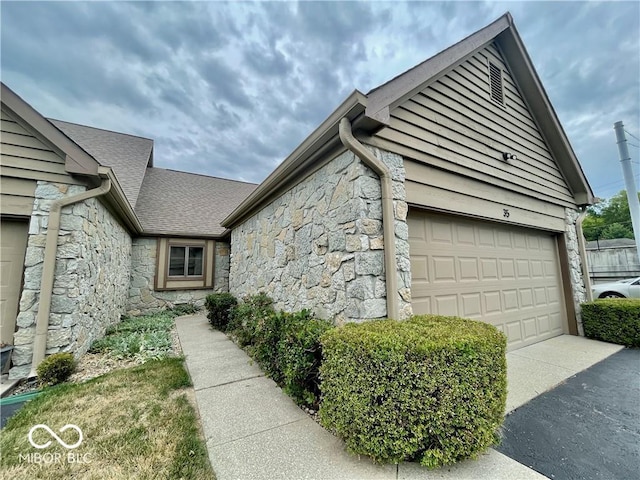 35 Northridge Ct, Brownsburg, IN 46112 - view of side of home with stone siding, driveway, a garage, and roof with shingles