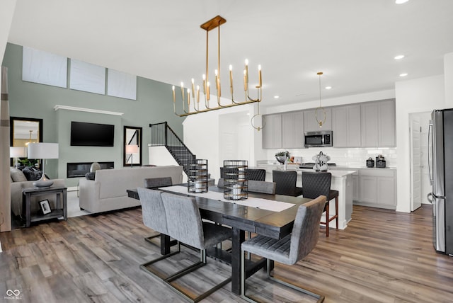 17040 Daly Dr, Noblesville, IN 46062 - dining area with wood finished floors, recessed lighting, stairs, and a glass covered fireplace