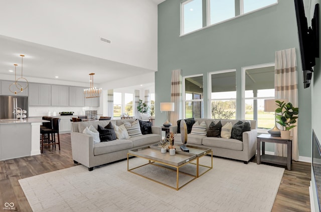 17040 Daly Dr, Noblesville, IN 46062 - living room featuring wood finished floors, healthy amount of natural light, a towering ceiling, a chandelier, and recessed lighting