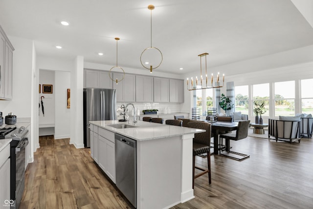17040 Daly Dr, Noblesville, IN 46062 - kitchen featuring appliances with stainless steel finishes, a center island with sink, recessed lighting, wood finished floors, and tasteful backsplash