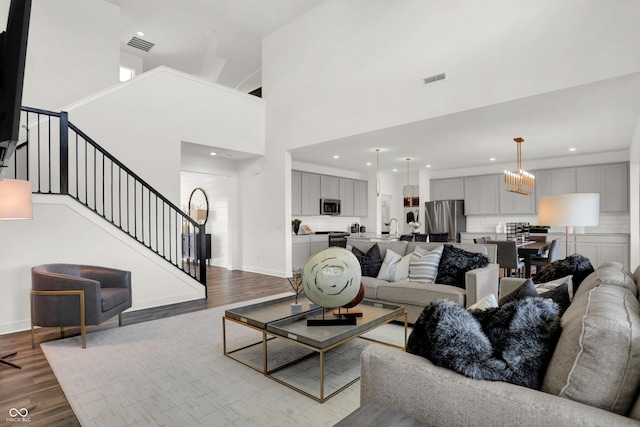 17040 Daly Dr, Noblesville, IN 46062 - living area with dark wood-type flooring, stairs, a high ceiling, recessed lighting, and a chandelier
