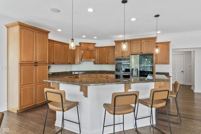 9877 Wading Crane Ave, Fishers, IN 46055 - kitchen with stainless steel appliances, custom exhaust hood, dark wood-style floors, an island with sink, and brown cabinets