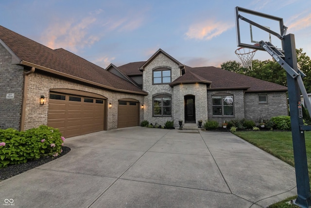 9877 Wading Crane Ave, Fishers, IN 46055 - french country home featuring a garage, driveway, a shingled roof, and brick siding