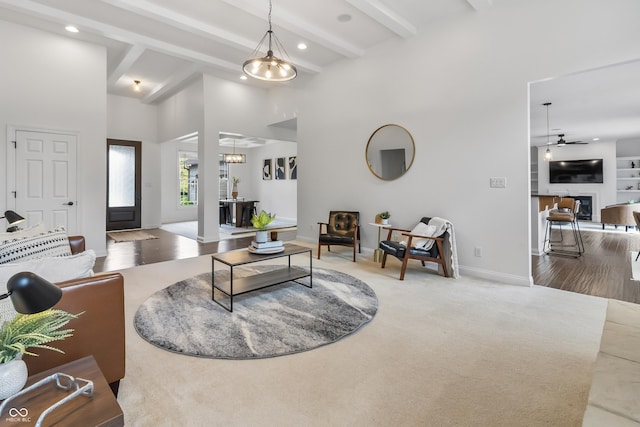 9877 Wading Crane Ave, Fishers, IN 46055 - carpeted living area featuring a ceiling fan, recessed lighting, beamed ceiling, a glass covered fireplace, and a towering ceiling