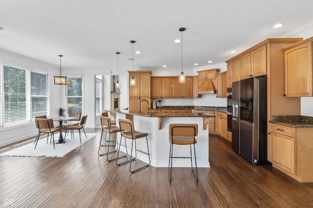 9877 Wading Crane Ave, Fishers, IN 46055 - kitchen with fridge with ice dispenser, dark wood-type flooring, a breakfast bar area, recessed lighting, and an island with sink