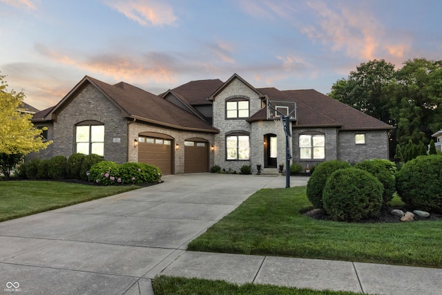 9877 Wading Crane Ave, Fishers, IN 46055 - french country style house with an attached garage, concrete driveway, brick siding, and a yard