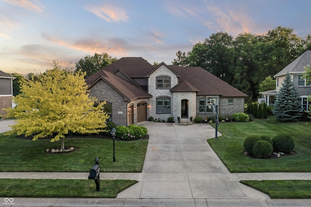 9877 Wading Crane Ave, Fishers, IN 46055 - french country style house with driveway, a front lawn, brick siding, stone siding, and an attached garage
