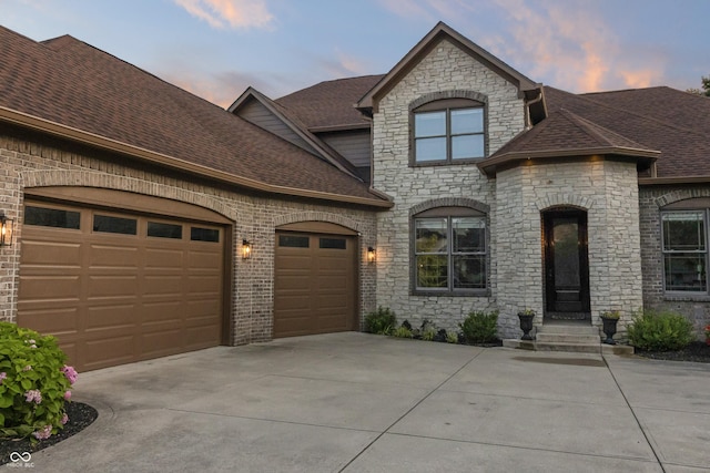 9877 Wading Crane Ave, Fishers, IN 46055 - french country inspired facade featuring concrete driveway, stone siding, roof with shingles, and a garage