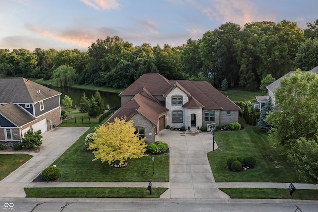 9877 Wading Crane Ave, Fishers, IN 46055 - view of front of house featuring driveway, a garage, a water view, and brick siding