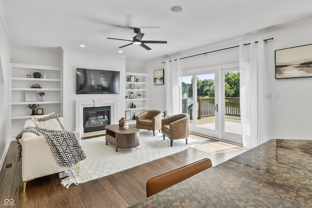 9877 Wading Crane Ave, Fishers, IN 46055 - living area featuring ceiling fan, wood finished floors, a glass covered fireplace, built in shelves, and recessed lighting