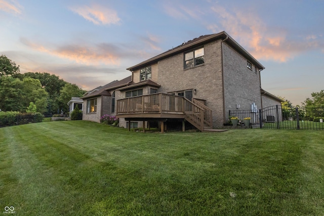 9877 Wading Crane Ave, Fishers, IN 46055 - back of house at dusk with a deck, stairs, and brick siding