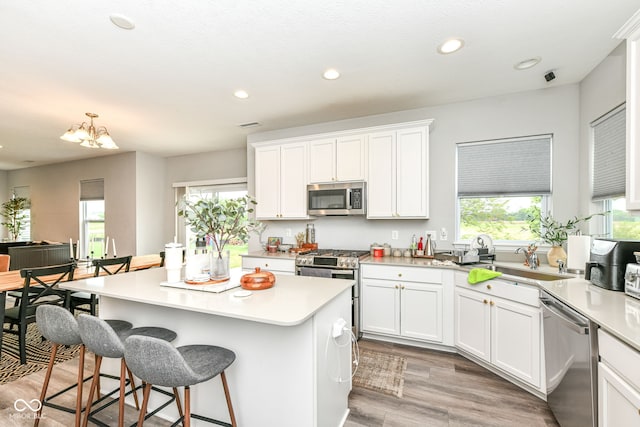 4309 Maize Ln, Whitestown, IN 46075 - kitchen featuring appliances with stainless steel finishes, a center island, white cabinets, a kitchen breakfast bar, and light countertops