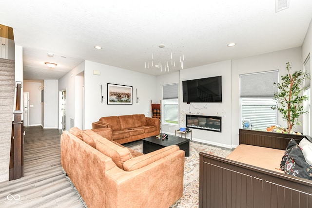 4309 Maize Ln, Whitestown, IN 46075 - living area with a glass covered fireplace, light wood-style flooring, and recessed lighting