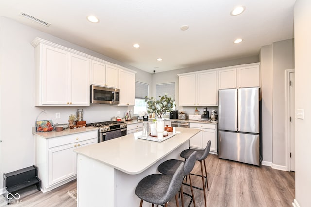 4309 Maize Ln, Whitestown, IN 46075 - kitchen with appliances with stainless steel finishes, light wood-type flooring, a center island, white cabinetry, and recessed lighting