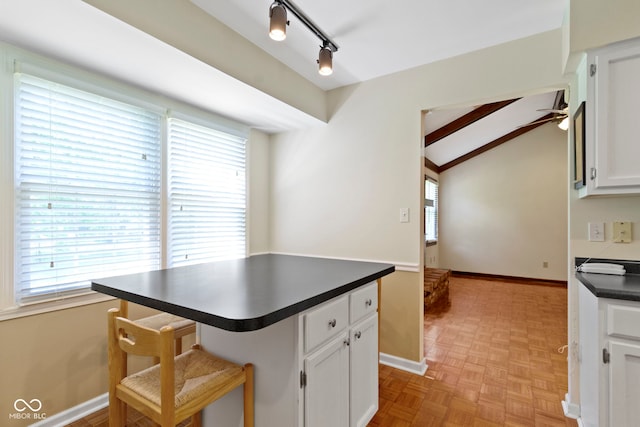4143 E 61st St, Indianapolis, IN 46220 - kitchen featuring dark countertops, white cabinets, healthy amount of natural light, and vaulted ceiling