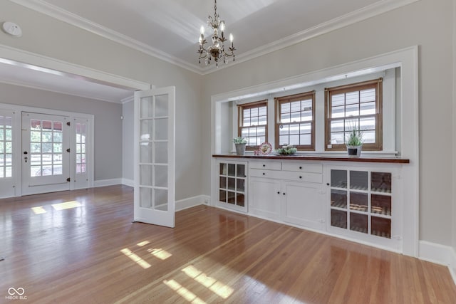 1005 Main St, Beech Grove, IN 46107 - unfurnished dining area with a chandelier, light wood-style floors, crown molding, and french doors