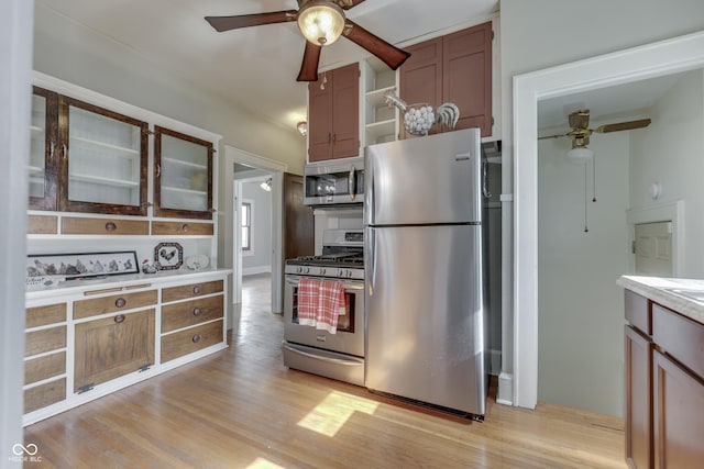 1005 Main St, Beech Grove, IN 46107 - kitchen featuring appliances with stainless steel finishes, a ceiling fan, light wood-style floors, and glass insert cabinets