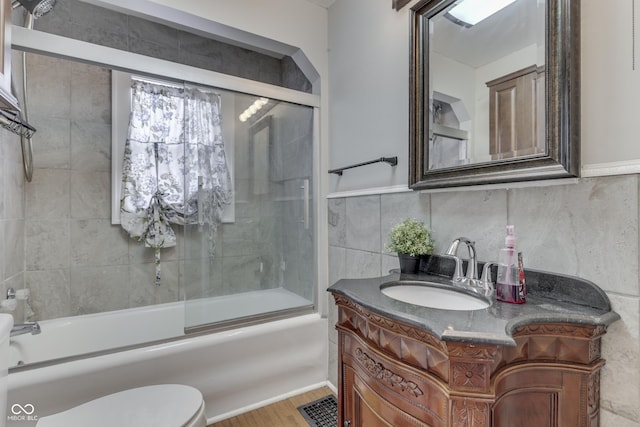 1005 Main St, Beech Grove, IN 46107 - bathroom featuring vanity, wood finished floors, combined bath / shower with glass door, and tile walls