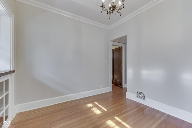 1005 Main St, Beech Grove, IN 46107 - empty room with a chandelier, crown molding, and light wood-type flooring