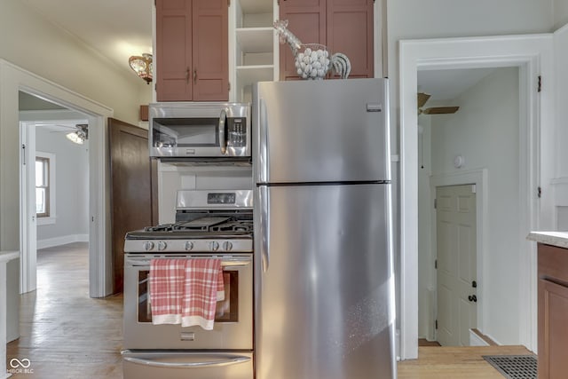 1005 Main St, Beech Grove, IN 46107 - kitchen with stainless steel appliances, a ceiling fan, and light wood-type flooring
