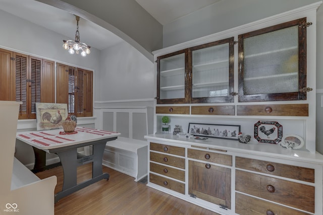 1005 Main St, Beech Grove, IN 46107 - dining space featuring a wainscoted wall, wood finished floors, arched walkways, a decorative wall, and a chandelier