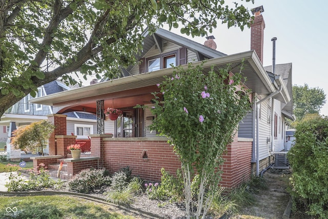1005 Main St, Beech Grove, IN 46107 - view of front of house featuring brick siding, a porch, and a chimney