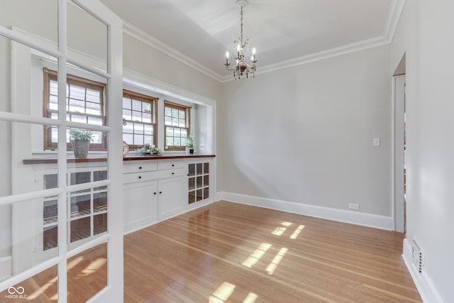 1005 Main St, Beech Grove, IN 46107 - unfurnished dining area featuring a chandelier, crown molding, and light wood-style flooring