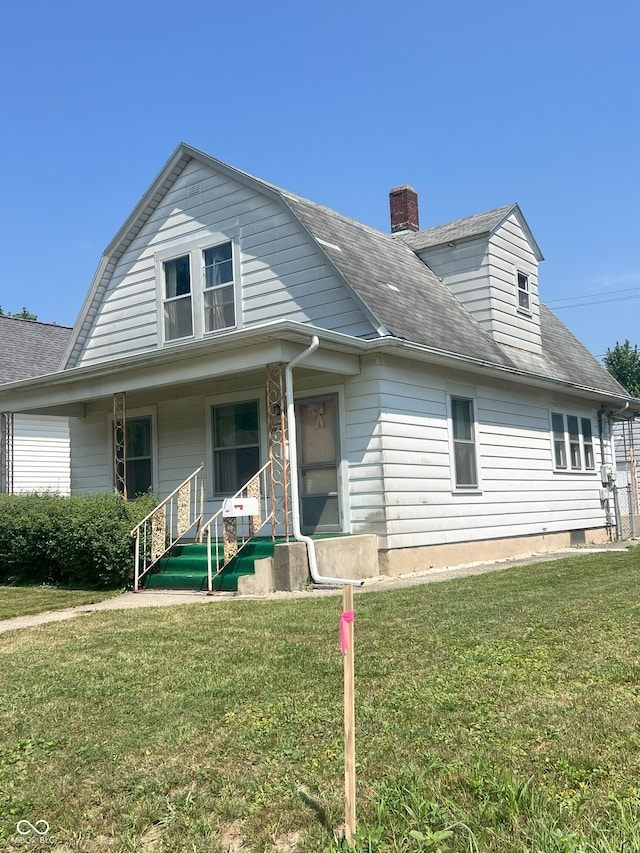 1652 High St, Fort Wayne, IN 46808 - view of front of house with a front yard, a porch, a gambrel roof, a chimney, and roof with shingles