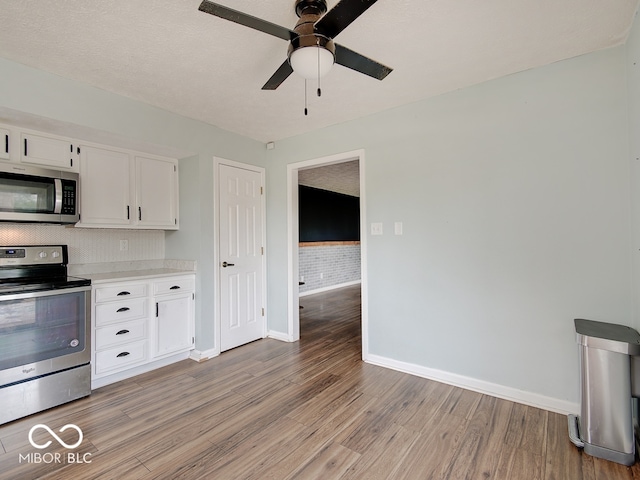 3902 Jekyll Ct, Indianapolis, IN 46237 - kitchen with appliances with stainless steel finishes, light wood-style flooring, a ceiling fan, light countertops, and white cabinets