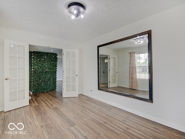 3902 Jekyll Ct, Indianapolis, IN 46237 - unfurnished room featuring french doors, wood finished floors, and a textured ceiling