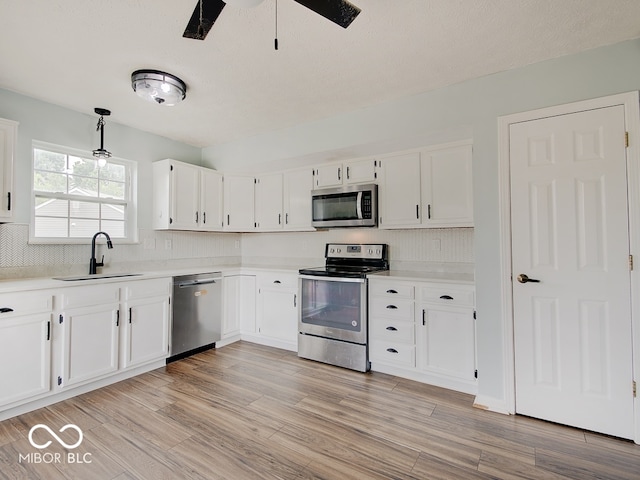 3902 Jekyll Ct, Indianapolis, IN 46237 - kitchen with appliances with stainless steel finishes, white cabinetry, light countertops, and light wood-style floors