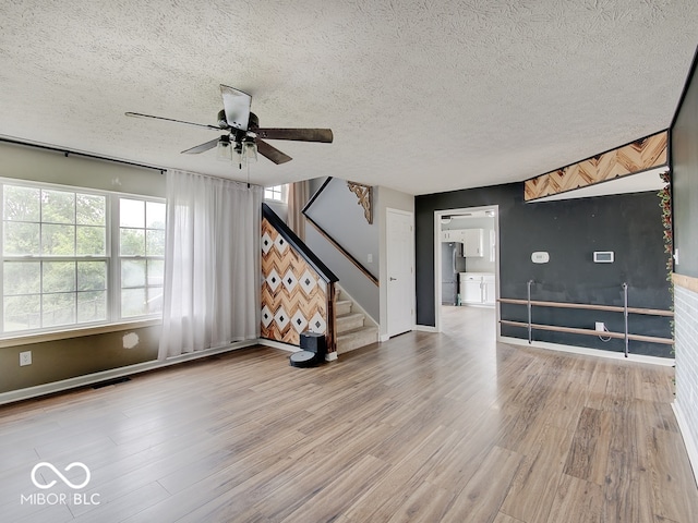 3902 Jekyll Ct, Indianapolis, IN 46237 - unfurnished living room with a ceiling fan, stairs, wood finished floors, and a textured ceiling