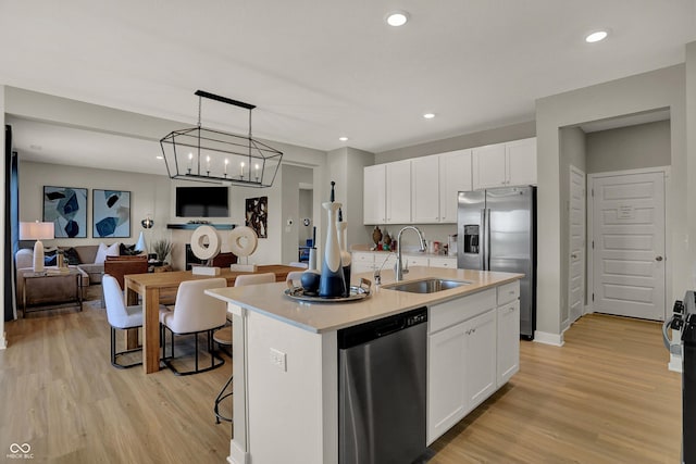 948 Shadow Dr, Danville, IN 46122 - kitchen featuring appliances with stainless steel finishes, light wood-type flooring, open floor plan, white cabinetry, and recessed lighting