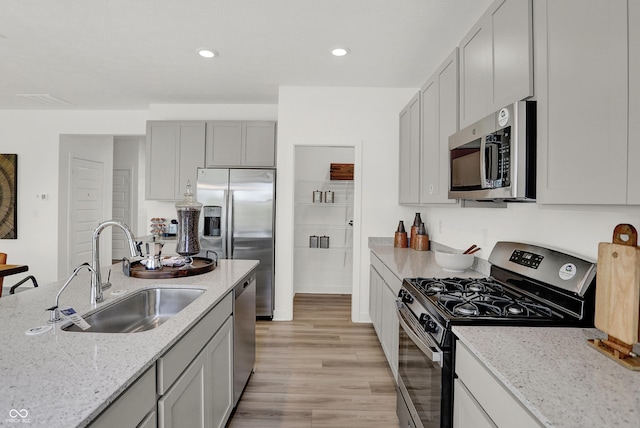 924 Shadow Dr, Danville, IN 46122 - kitchen featuring stainless steel appliances, light wood finished floors, light stone countertops, recessed lighting, and gray cabinetry