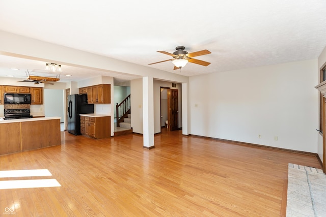 6926 Princess Ln, Avon, IN 46123 - unfurnished living room featuring ceiling fan, stairway, and light wood-style flooring