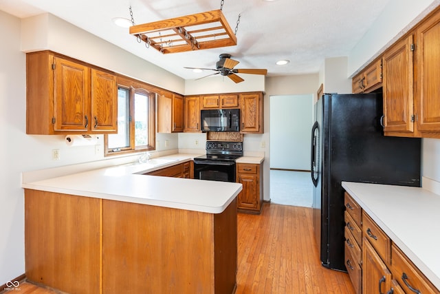 6926 Princess Ln, Avon, IN 46123 - kitchen featuring black appliances, a ceiling fan, a peninsula, brown cabinetry, and recessed lighting