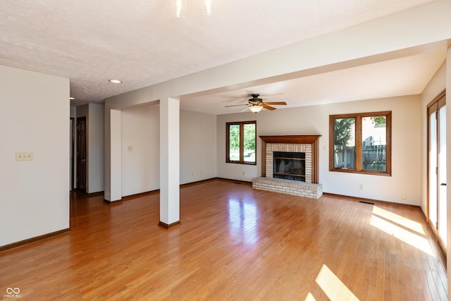 6926 Princess Ln, Avon, IN 46123 - unfurnished living room featuring light wood-style flooring, a brick fireplace, ceiling fan, a textured ceiling, and recessed lighting