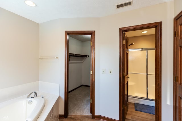 6926 Princess Ln, Avon, IN 46123 - bathroom featuring a stall shower, a garden tub, recessed lighting, wood finished floors, and a spacious closet