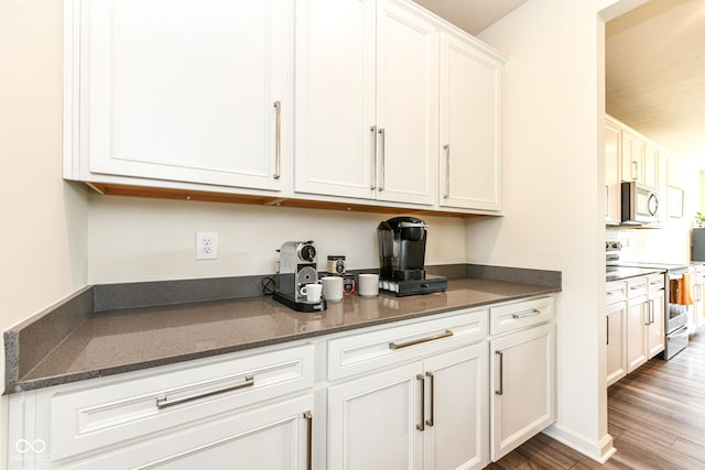 7101 Oak Trace Ln, Brownsburg, IN 46112 - kitchen featuring stainless steel appliances, white cabinetry, wood finished floors, and dark stone counters